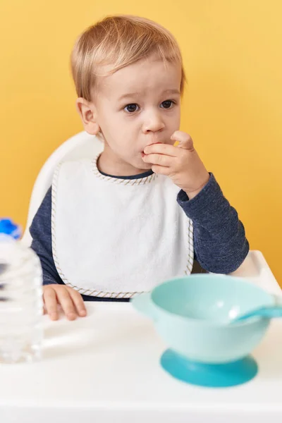Entzückende Blonde Kleinkind Sitzt Auf Hochstuhl Essen Snack Über Isolierten — Stockfoto