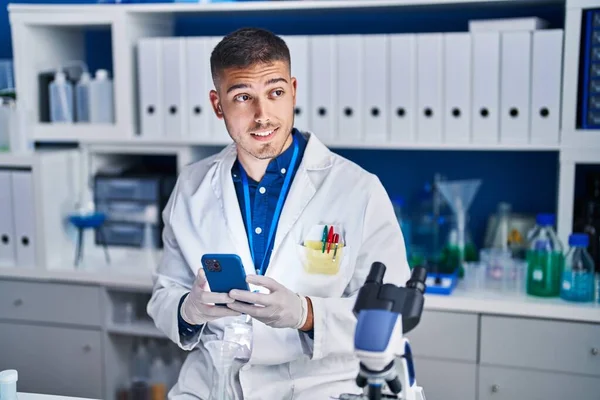 Young Hispanic Man Scientist Using Smartphone Laboratory — ストック写真