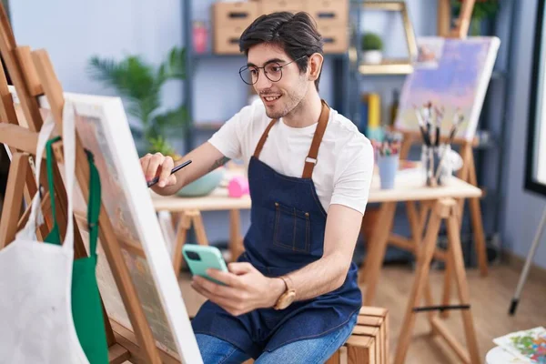 Young Hispanic Man Artist Using Smartphone Drawing Art Studio — Stockfoto