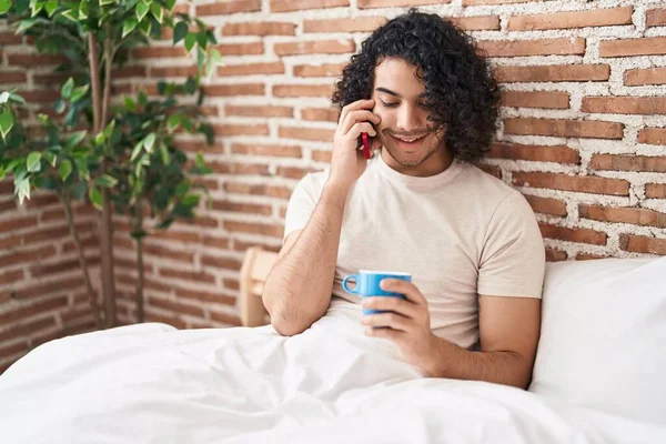 Genç Latin Adam Akıllı Telefonda Konuşuyor Yatak Odasında Kahve Içiyor — Stok fotoğraf