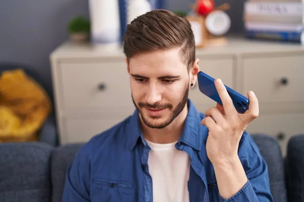 Mladý Kavkazský Muž Poslouchá Hlasovou Zprávu Smartphonu Sedí Pohovce Doma — Stock fotografie