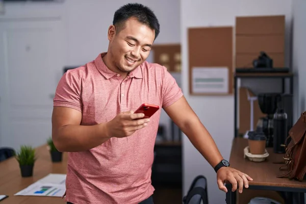 Genç Çinli Adamı Ofisteki Akıllı Telefonu Kullanarak Gülümsüyor — Stok fotoğraf