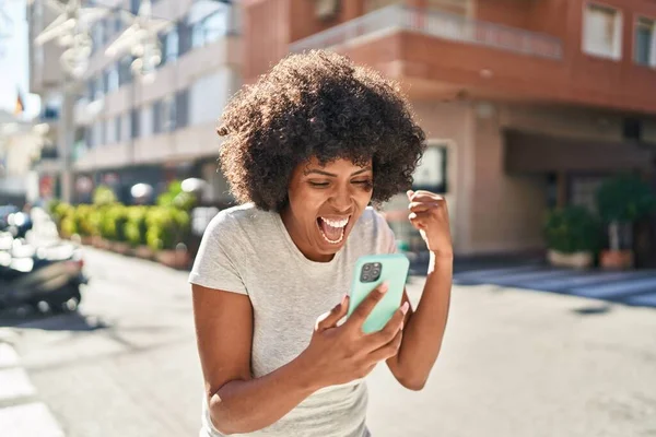 Afrikkalainen Amerikkalainen Nainen Käyttää Älypuhelinta Voittaja Ilme Kadulla — kuvapankkivalokuva
