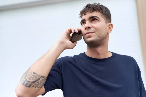 Young Hispanic Man Talking Smartphone Serious Expression Street — Φωτογραφία Αρχείου