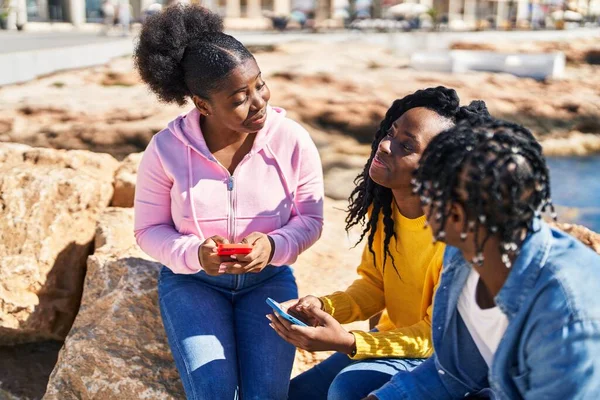 Amigos Afroamericanos Usando Teléfono Inteligente Sentado Roca Playa —  Fotos de Stock