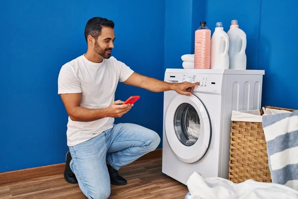 Young Hispanic Man Turning Washing Machine Using Smartphone Laundry Room — Stock Photo, Image