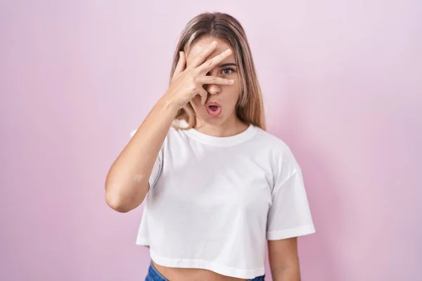 Young Blonde Woman Standing Pink Background Peeking Shock Covering Face — 图库照片