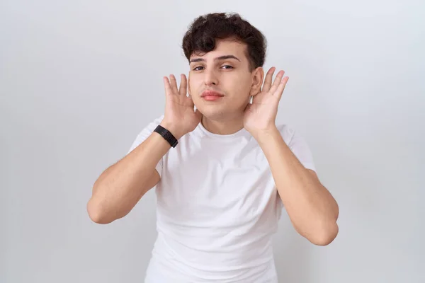 Молодой Двоичный Человек Обычной Белой Футболке Пытается Услышать Обе Руки — стоковое фото