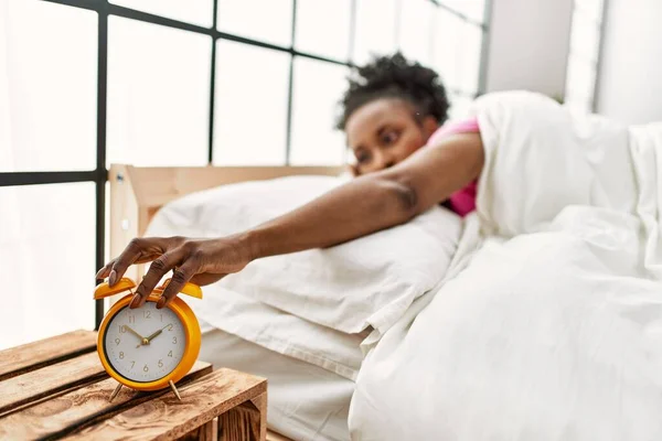 Αφροαμερικανή Γυναίκα Που Κλείνει Ξυπνητήρι Ξαπλωμένη Στο Κρεβάτι Στο Υπνοδωμάτιο — Φωτογραφία Αρχείου