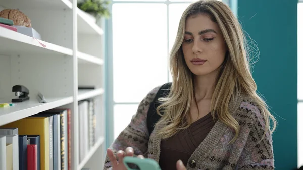 Молодая Блондинка Студентка Использующая Смартфон Стоящий Библиотечном Университете — стоковое фото