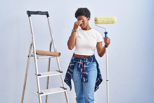 Mulher Afro Americana Segurando Pintor Rolos Cansado Esfregando Nariz Olhos — Fotografia de Stock