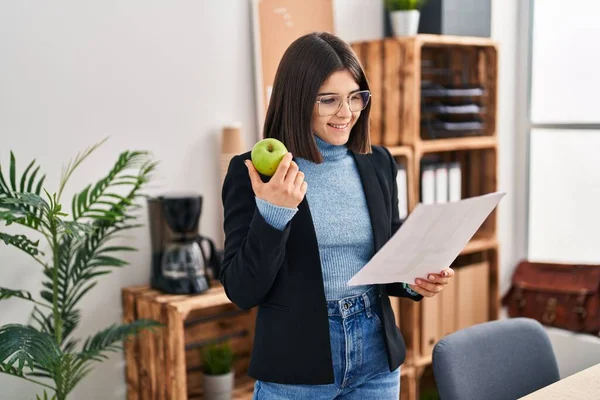 Junge Schöne Hispanische Geschäftsfrau Liest Dokument Und Isst Büro Apfel — Stockfoto