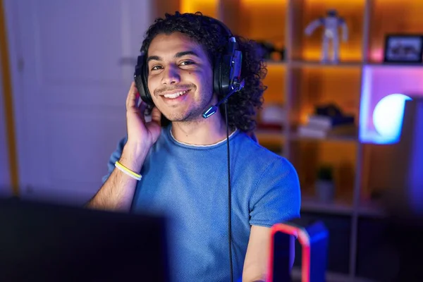 stock image Young latin man streamer smiling confident sitting on table at gaming room