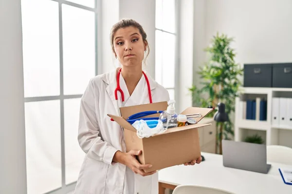 Jovem Médico Mulher Segurando Caixa Com Itens Médicos Soprando Bochechas — Fotografia de Stock