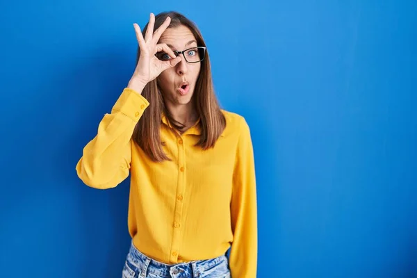 Ung Kvinna Bär Glasögon Stående Över Blå Bakgrund Gör Gest — Stockfoto