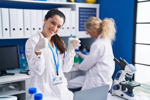 Mulher Hispânica Jovem Trabalhando Laboratório Cientista Sorrindo Feliz Positivo Polegar — Fotografia de Stock