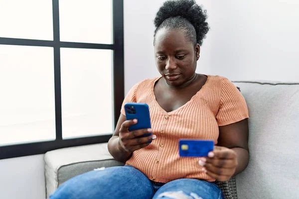 Mujer Afroamericana Joven Usando Teléfono Inteligente Tarjeta Crédito Sentado Sofá — Foto de Stock