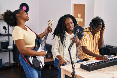 Afrika kökenli Amerikalı müzisyenler müzik stüdyosunda şarkı söylüyorlar.