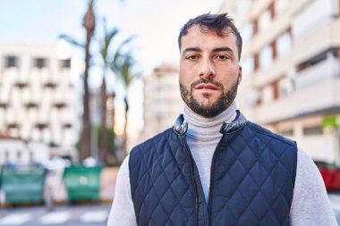 Sokakta dikilen ciddi ifadeli genç bir İspanyol.