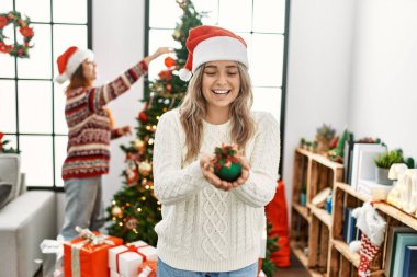 Evde elinde Noel balosu süsleyen bir çift var.