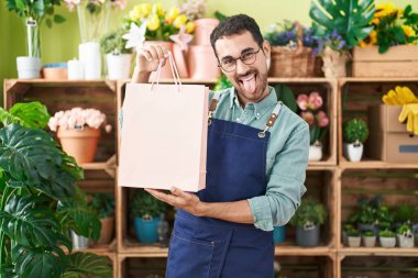 Çiçekçide çalışan yakışıklı İspanyol adam komik bir ifadeyle dilini dışarı çıkarıyor.. 