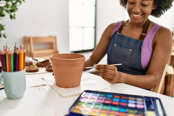 在艺术工作室里 年轻的非洲裔美国女人笑着自信地画泥壶 — 图库照片