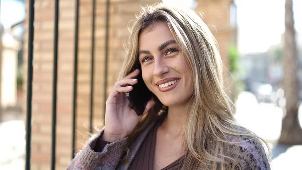 Mujer Rubia Joven Sonriendo Confiada Hablando Teléfono Inteligente Calle —  Fotos de Stock