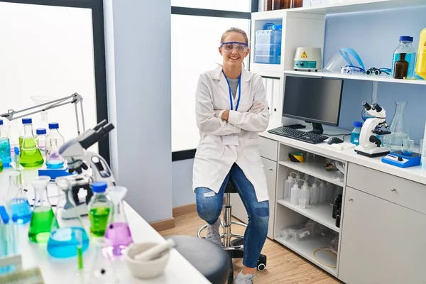 Young Blonde Woman Wearing Scientist Uniform Sitting Arms Crossed Gesture — Stock Photo, Image
