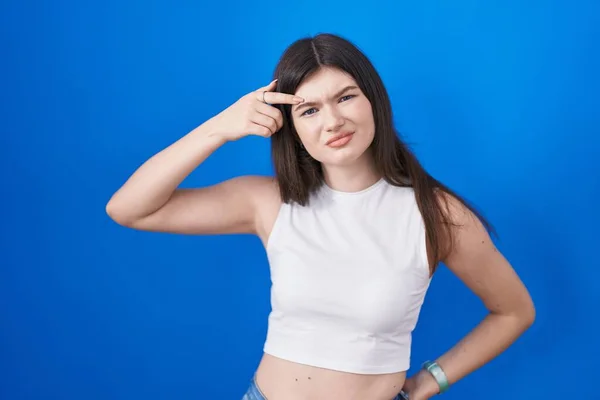 Young Caucasian Woman Standing Blue Background Pointing Unhappy Pimple Forehead — Stockfoto