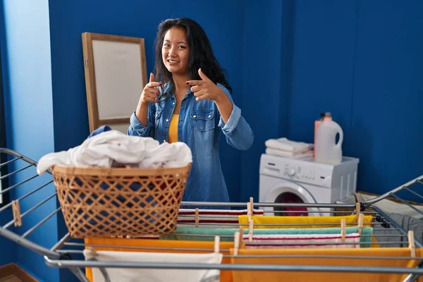 Mladá Asiatka Věší Oblečení Prádelní Šňůru Ukazující Prsty Kameru Šťastnou — Stock fotografie