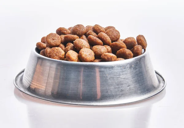 Delicious bowl of dog food balls over isolated white background