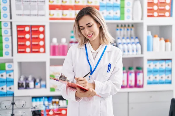Young Woman Pharmacist Smiling Confident Writing Document Pharmacy — стоковое фото