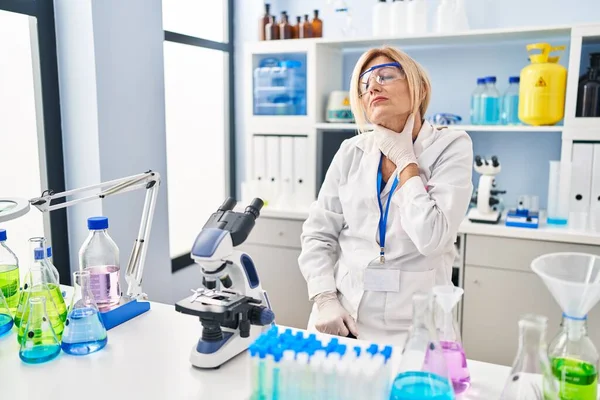 Mulher Loira Meia Idade Trabalhando Laboratório Cientista Tocando Pescoço Doloroso — Fotografia de Stock
