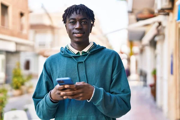 非裔美国人在街上用智能手机充满自信地微笑 — 图库照片