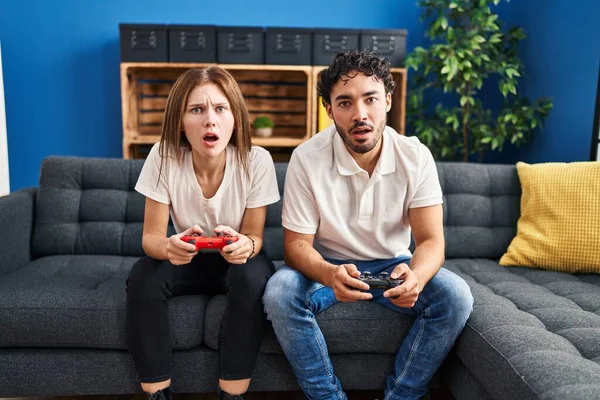 Unga Par Spelar Spel Håller Controller Hemma Rädd Och Förvånad — Stockfoto