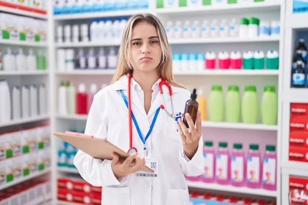 Joven Mujer Rubia Que Trabaja Farmacia Farmacia Sosteniendo Botella Deprimida —  Fotos de Stock