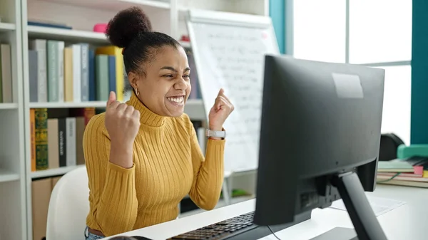 図書館でお祝いのコンピュータを使用して若いアフリカ系アメリカ人女性の学生 — ストック写真