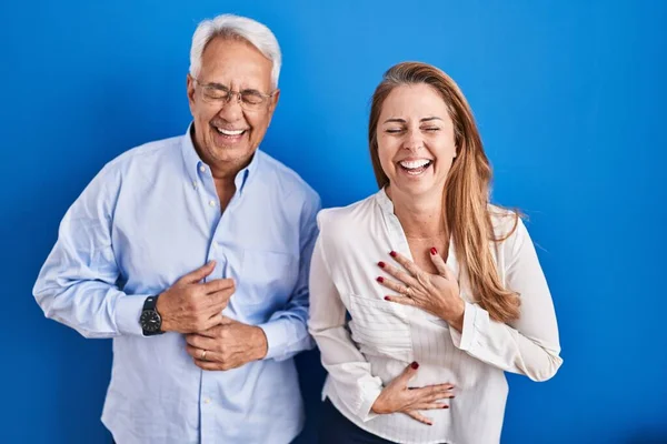 Middelbare Leeftijd Hispanic Paar Staan Blauwe Achtergrond Lachen Hard Lachen — Stockfoto
