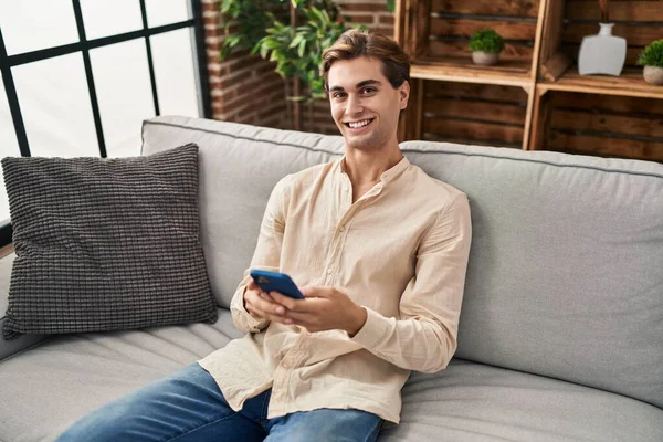 Mladý Kavkazský Muž Pomocí Smartphonu Sedí Pohovce Doma — Stock fotografie