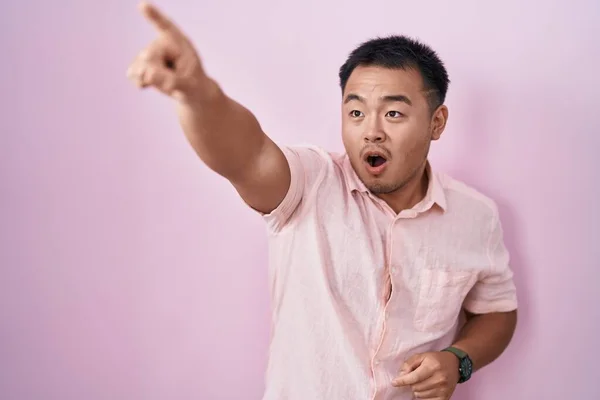 Chinese Young Man Standing Pink Background Pointing Finger Surprised Ahead — Stock Photo, Image