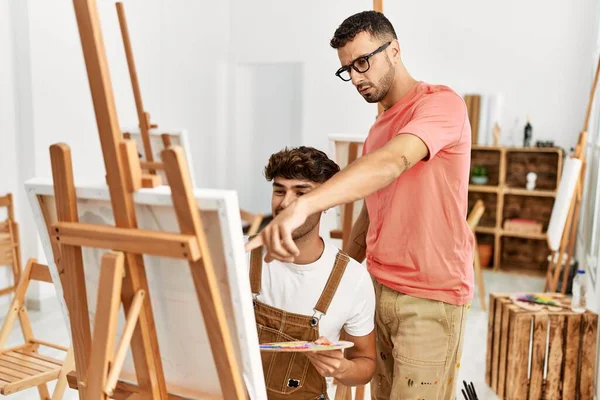 2人のヒスパニック系の男性教師と学生がアートスタジオで描く — ストック写真