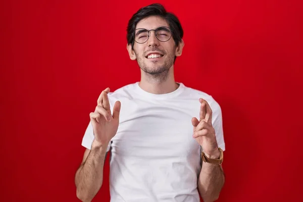 Mladý Hispánec Který Stál Nad Červeným Pozadím Ukazoval Prstem Usmíval — Stock fotografie