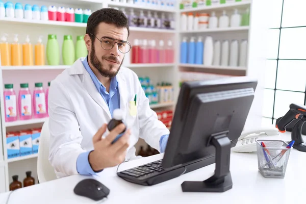 Young Hispanic Man Pharmacist Using Computer Holding Medication Bottle Pharmacy — Stock Photo, Image