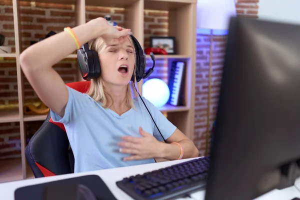 Young Caucasian Woman Playing Video Games Wearing Headphones Touching Forehead — Stock Photo, Image
