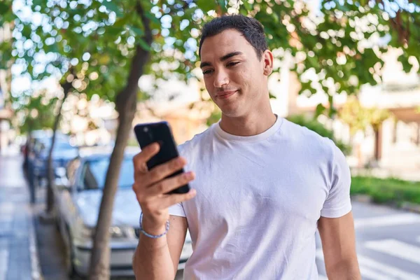 Młody Hiszpan Uśmiecha Się Pewnie Używając Smartfona Ulicy — Zdjęcie stockowe
