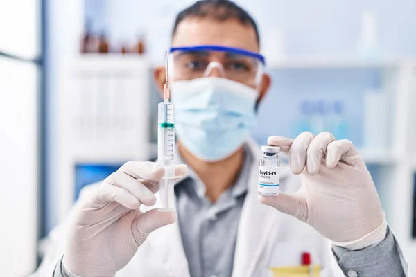 Young Hispanic Man Scientist Holding Covid Vaccine Laboratory — Stok fotoğraf