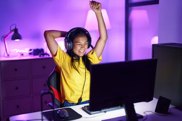 stock image Young beautiful latin woman streamer playing video game with winner expression at gaming room