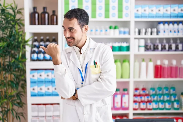 Красивый Латиноамериканец Работающий Аптеке Улыбается Счастливым Лицом Указывает Сторону Большим — стоковое фото