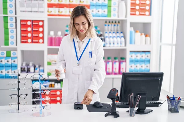 Young Woman Pharmacist Charging Pills Bottle Using Credit Card Pharmacy — Stockfoto