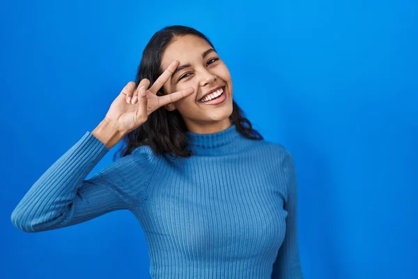 Young Brazilian Woman Standing Blue Isolated Background Doing Peace Symbol — Fotografia de Stock
